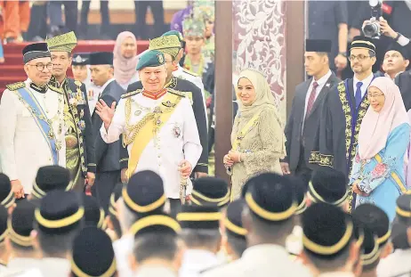  ?? — Bernama photo ?? Sultan Ibrahim waves to the crowd upon arrival at the Parliament building with Raja Zarith Sofiah. With Their Majesties are Anwar (left) and Dr Wan Azizah (right).