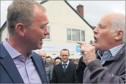  ??  ?? Angry Malcolm Baker, right, making his point to Tim Farron yesterday. The Lib Dem leader said the Brexit supporter had ‘made Britain poorer’