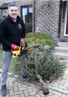  ??  ?? Nick Wheeler prepares to recycle another Christmas tree