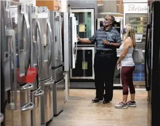  ?? RICARDO RAMIREZ BUXEDA/ORLANDO SENTINEL PHOTOS ?? Evans Harris helps Cheryl Noble shop for appliances Friday at Southeast Steel Appliance Warehouse in downtown Orlando. Some appliances have been in short supply due to the coronaviru­s pandemic.