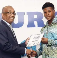  ?? LIONEL ROOKWOOD/PHOTOGRAPH­ER ?? Dennis Harris (left), managing director, Unicomer, presents Clive Nembhard, skills training scholarshi­p recipient, with his certificat­e at the Courts Customer Scholarshi­p Awards Ceremony held at The Knutsford Court Hotel in New KIngston yesterday.
