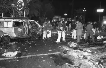  ??  ?? Pakistani police officials and volunteers move the bodies of victims at the site of a bomb explosion in Lahore. — AFP photo