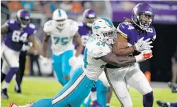  ?? BRUCE KLUCKHOHN/AP ?? Minnesota tight end Bucky Hodges is hauled down by Dolphins linebacker Deon Lacey after making a reception.