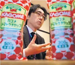  ?? REUTERS ?? Fumitaka Ono, a manager in Kagome’s product developmen­t department, speaks behind its packaged tomato ketchup bottles during an interview at the company headquarte­rs in Tokyo.