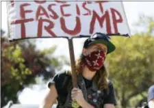  ?? MARCIO JOSE SANCHEZ - THE ASSOCIATED PRESS ?? A protester holds up a sign outside of Alamo Square Park in San Francisco, Saturday. San Francisco officials took further steps Saturday to prevent violence ahead of a planned news conference by a right-wing group. Officials erected fencing and a large...