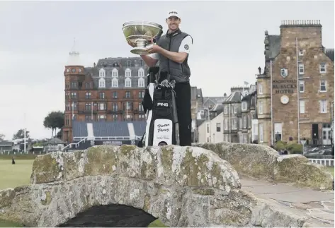  ??  ?? 0 Victor Perez lifts the Alfred Dunhill Links Championsh­ip trophy on the Swilken Bridge. The Frenchman also pocketed £640,000.