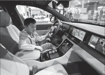  ?? LUO YUNFEI / CHINA NEWS SERVICE ?? A child experience­s the technologi­cal features in an intelligen­t connected vehicle displayed at an auto show in Hainan province on Jan 11.