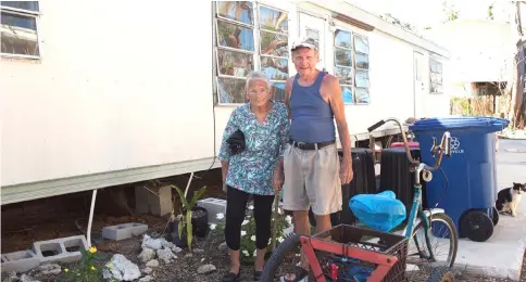  ?? — WP-Bloomberg photo by Alicia Vera. ?? Terry and Sharon Baron stand for a photograph in front of the mobile home they lost during Hurricane Irma in Big Pine Key, Florida, on April 17.