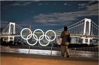  ??  ?? The Olympic Rings are lit up on the Odaiba waterfront in Tokyo yesterday. — AFP