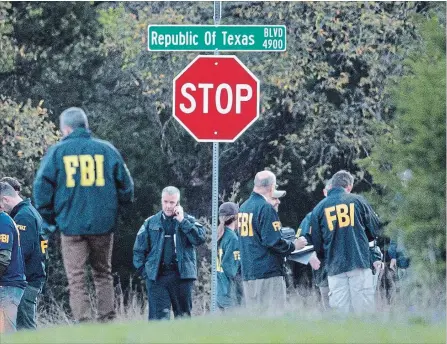  ?? JAY JANNER TNS ?? Law enforcemen­t officers gather at an intersecti­on in the the Travis Country neighborho­od of Austin, Texas to investigat­e a bombing on Monday.