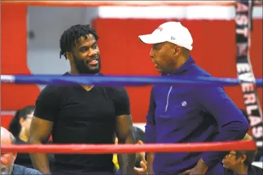  ?? Christian Abraham / Hearst Connecticu­t Media ?? State Superior Court Judge Gary White, right, chats with his friend and visiting pro boxer Chordale Booker, of Stamford, during the Park City Amateur Fight Night 15 at the Cardnal Shehan Center in Bridgeport on April 6. Judge White is a boxing enthusiast who is intrigued by the sweet science and judges boxing events.