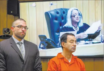  ?? Cory Morse ?? The Associated Press Larry Nassar, right, listens next to defense attorney Matthew Newberg as Judge Janice Cunningham, seen on a monitor, sentences Nassar on Monday at Eaton County Circuit Court in Charlotte, Mich.