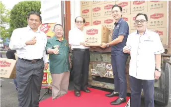  ??  ?? Uggah (centre) and Tho hold a box of banaBee banana chips meant for export. Also seen from left are Dr Ismail, Sagah and Awang Bemee.