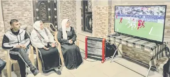  ?? — AFP photo ?? The family member of Palestine’s defender and captain Musab al-Battat watch the live television broadcast of the AFC Asian Cup football match between Qatar and Palestine, at their family home in the village of al-Dhahiriya south of Hebron in the occupied West Bank.