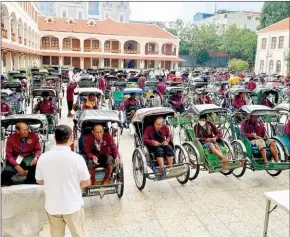  ?? CITY HALL ?? Phnom Penh deputy governor Meth Meas Pheakdey hands care packages to cyclo drivers on May 28.