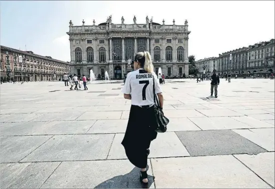  ?? ISABELLA BONOTTO / AFP ?? Una joven paseaba ayer por Turín luciendo la camiseta de Cristiano Ronaldo, que jugará en el Juventus