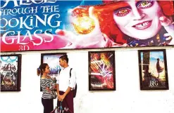  ??  ?? A couple standing next to movie posters at the Naypyidaw cinema in downtown area of Yangon.