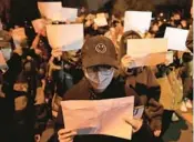  ?? GUAN/AP NG HAN ?? Protesters hold up blank sheets of paper, a symbol of defiance against China’s censorship, on Sunday in Beijing.