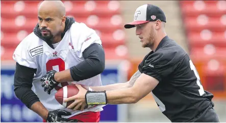  ?? ARYN TOOMBS/ CALGARY HERALD ?? Calgary Stampeders running back Jon Cornish, left, gets the hand- off from quarterbac­k Bo Levi Mitchell during practice on Monday. Cornish had his first 100- yard game of the season Saturday against Winnipeg, due in no small part to new offensive...