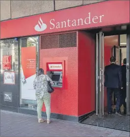  ?? EFE ?? Una mujer utiliza un cajero automático de Banco Santander.