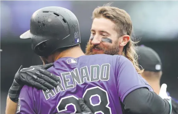  ??  ?? The Rockies’ Charlie Blackmon congratula­tes Nolan Arenado for walking with the bases loaded in the ninth inning Thursday.