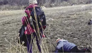  ??  ?? MIRATOVAC: A child strapped with his mother falls as he walks with other migrants and refugees after crossing the Macedonian border into Serbia, near the village of Miratovac yesterday. More than one million migrants and refugees crossed the...