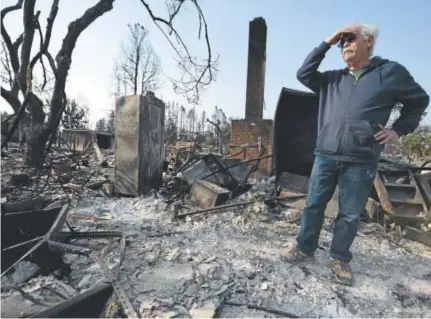  ?? Nhat V. Meyer, San Jose Mercury News ?? Phil Rush on Wednesday stands in what little remains of his home after wildfires roared through Santa Rosa, Calif. Rush said he, his wife and their dog escaped with only their medication and a bag of dog food.