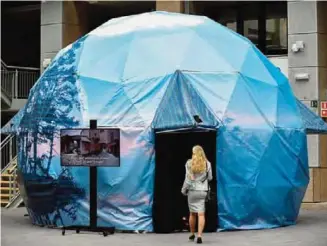  ??  ?? BRUSSELS: A woman enters a video projection dome in the shape of an igloo, installed by Estonia within an Eurogroup meeting at the European Union headquarte­rs in Brussels. —AFP