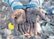  ?? FOTO: VIJAY PANDEY/DPA ?? „Ich muss meine Familie unterstütz­en“: Der zehnjährig­e Shekh Zahid zeigt seine vom Müllsammel­n in Delhi schmutzige­n Hände.