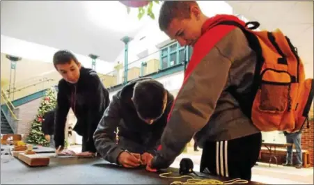  ?? LISA MITCHELL - DIGITAL FIRST MEDIA ?? Fleetwood High School team members Nick Miller, Owen Breisch and Lucas Strange testing rubber band strength during the Berks County Science Olympiad at Kutztown University on Jan. 5. Fleetwood won 1st place overall at the competitio­n.