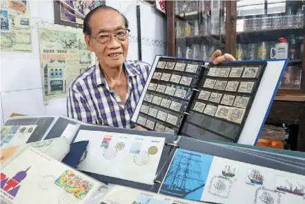  ?? ?? Prized possession: Wong showing off his collection of old stamps and first day covers at his shop in Paloh Kluang, Johor. — Thomas yong/the Star