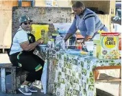  ?? Picture: SIMPHIWE NKWALI ?? POWER SNACK: Nomvula Mokonyane samples the wares on offer at a taxi rank in Uitenhage this week