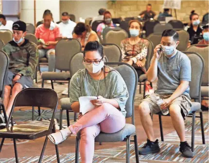  ?? SUE OGROCKI/AP ?? People wait to speak with representa­tives from the Oklahoma Employment Security Commission about unemployme­nt claims in July in Midwest City, Okla.