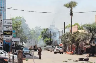  ?? LUDIVINE LANIEPCE THE ASSOCIATED PRESS ?? A soldier walks near army headquarte­rs in Ouagadougo­u. Gunfire rocked Burkina Faso’s capital Friday.