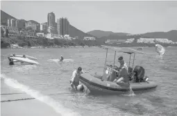  ?? ISAAC LAWRENCE/GETTY-AFP ?? Lifeguards in Hong Kong work Thursday after some COVID-19 restrictio­ns were relaxed. Among them included the reopening of beaches and pools.