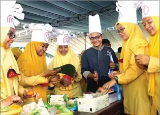  ?? GUSLAN GUMILANG/JAWA POS ?? LESTARIKAN KULINER: M. Hamzah (tiga dari kanan) menilai masakan kelompok Afisa Adelia (kanan) dari kelas XII MIPA.