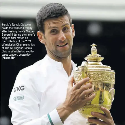  ?? (photo: afp) ?? Serbia’s Novak Djokovic holds the winner’s trophy after beating Italy’s Matteo Berrettini during their men’s singles final match on the 13th day of the 2021 Wimbledon Championsh­ips at The All England Tennis Club in Wimbledon, southwest London, yesterday.