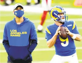  ?? HARRY HOW GETTY IMAGES ?? Starting quarterbac­k Jared Goff (left) looks on as backup John Wolford warms up before the Rams defeated the Arizona Cardinals at SoFi Stadium on Sunday. The Rams need Goff on the field Saturday.