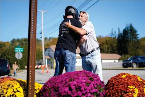  ?? ?? Richard Morlock, right, a member of the deaf community and surviver of the mass shooting at Schemengee­s Bar and Grille, embraces a person Saturday at a makeshift memorial in Lewiston, Maine. (AP Photo/matt Rourke)