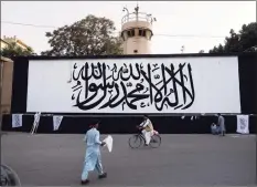  ?? Bernat Armangue / Associated Press ?? The iconic Taliban flag is painted on a wall outside the American embassy compound in Kabul, Afghanista­n, on Saturday.