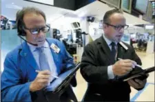  ?? RICHARD DREW — THE ASSOCIATED PRESS ?? Traders Sal Suarino, left, and Robert Arciero work on the floor of the New York Stock Exchange, Wednesday.