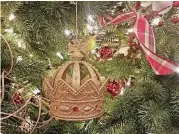  ?? [PHOTO PROVIDED BY MARNI JAMESON] ?? This crown ornament, which the author and her husband picked up on a recent trip to England’s Tower of London, forms the foundation for a tree that will evolve over years to reflect their newly blended family, travels and passions. Coordinati­ng ribbon and red ornaments give the tree unity.