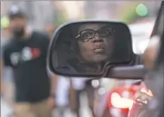  ??  ?? Desaray McCray of the North Side is reflected in her car's side mirror as she watches protesters march along Sixth Avenue. "I feel fine about it," Ms. McCray said about being stuck in traffic. "I mean, I have four sons and I understand the plight. Something needs to change."