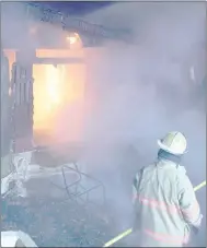  ?? Keith Bryant/The Weekly Vista ?? Bella Vista deputy fire chief Bryan Wolfgang stands back as the home on Ciemny Lane burns.