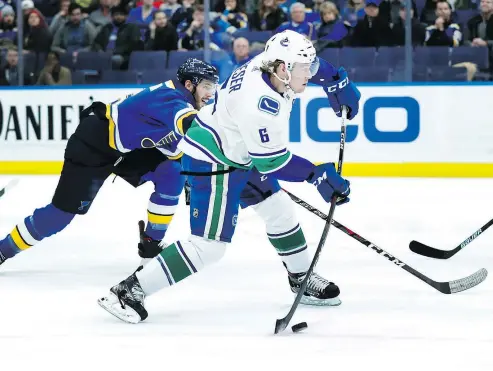  ?? — THE ASSOCIATED PRESS ?? Vancouver Canucks’ Brock Boeser shoots as St. Louis Blues’ Joel Edmundson defends during the first period on Sunday in St. Louis. Boeser went on to complete a hat trick, with help from Elias Pettersson