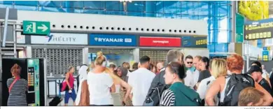  ?? JAVIER ALBIÑANA ?? Pasajeros haciendo cola en el aeropuerto de Málaga para reclamar ante la huelga de Ryanair.