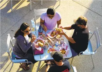  ?? NELVIN C. CEPEDA U-T ?? (Clockwise from top) Christine and Ben Villanueva and Livingston and Erin Morehouse enjoy some Hodad’s burgers at Snapdragon Stadium during a scrimmage game on Saturday.