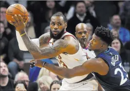  ?? Jim Mone ?? The Associated Press Cavaliers forward Lebron James seeks help while hounded by Timberwolv­es guard Jimmy Butler in the first half of Minnesota’s 127-99 win Monday at Target Center.