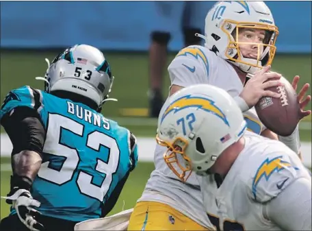  ?? Robert Gauthier Los Angeles Times ?? THE CHARGERS’ Justin Herbert was sacked twice against Carolina on Sunday and f igures to see more of the same in Tampa Bay.