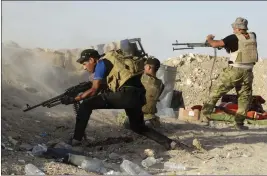  ?? THE ASSOCIATED PRESS ?? Iraqi security forces defend their positions against an Islamic State attack in Husaybah, 8 kilometers (5miles) east of Ramadi, on June 15, 2015.